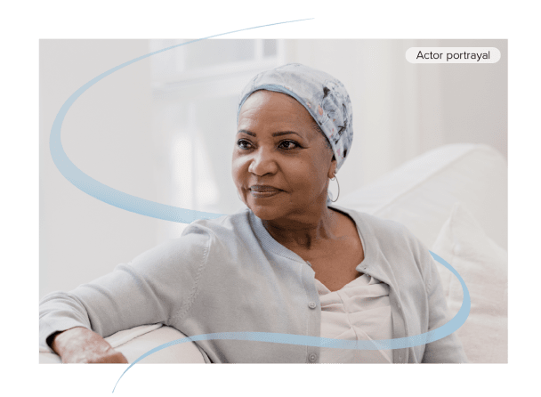 Actor portrayal of woman with cancer sitting indoors